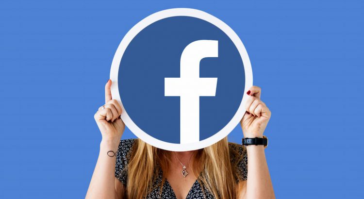 Uma mulher segurando um cartaz com o logotipo do facebook, representando a criação de uma copy para anúncios do facebook