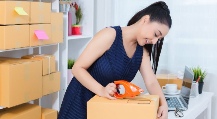 Mulher lojista embalando um produto pronto para entrega em seu ambiente de trabalho