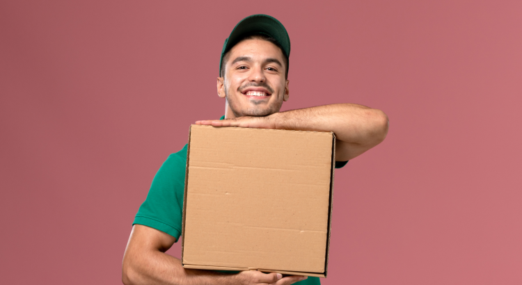 Entregador sorrindo e segurando uma caixa de entrega com as duas mãos